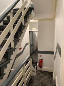 una escalera en un edificio con un extintor de incendios rojo en Urban Inn, en Blackpool