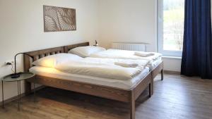 a bedroom with two beds with white sheets at Apartmány U stezek in Lipova Lazne