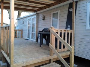 una terraza de madera en el lateral de una casa en MOBIL-HOME 6-8 pers, Domaine de Kerlann 4* en Pont-Aven