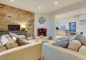 sala de estar con 2 sofás y chimenea en 2 Railway Cottages en Selside
