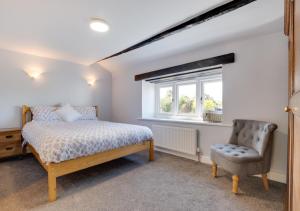 a bedroom with a bed and a chair and a window at 3 Ivy Terrace in Bradley