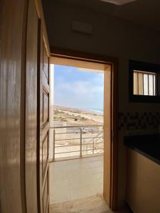 a door to a room with a view of the beach at House of banana beach aourir in Aourir