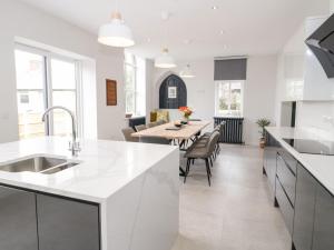 a kitchen with white countertops and a dining room at Salem in Prestatyn