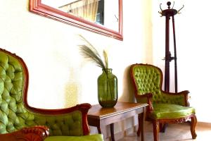 Zimmer mit 2 Stühlen und einer Vase auf einem Tisch in der Unterkunft Cleo in Spáta