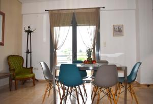 ein Esszimmer mit einem Tisch, Stühlen und einem Fenster in der Unterkunft Cleo in Spáta