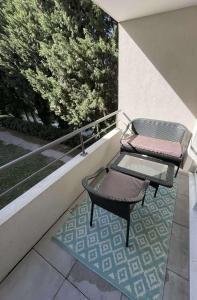2 chaises et une table sur un balcon dans l'établissement Appartement en résidence-Avignon, à Avignon