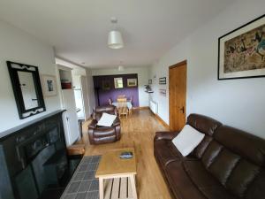uma sala de estar com um sofá e uma mesa em Roadside Cottage The Burren em Kilfenora