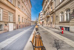 an empty street with yellow benches in a city at happy home BLUE - apartment with free Pinball Machine in Budapest