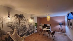 a living room with a mural of palm trees on the wall at Le Dôme du Lac in Ardres
