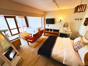 a bedroom with a large bed and a living room at Fizzio Alaçatı Hotel in Alaçatı