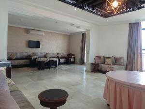 ein großes Wohnzimmer mit Sofas und Fernseher in der Unterkunft Residence La corniche Étage 2 in Nador
