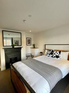 ein Schlafzimmer mit einem großen Bett und einem Kamin in der Unterkunft Booking Urban at Stisted in Braintree