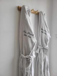 two towels with writing on them hanging on a wall at Les Secrets du Lac in Ardres