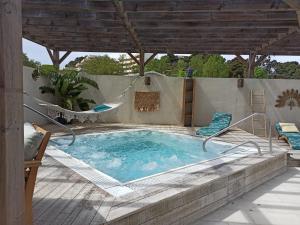 a swimming pool on a patio with a pergola at Mobil home Camping 4* La Falaise Narbonne Plage in Narbonne-Plage