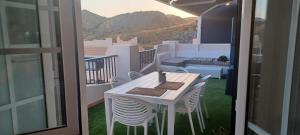 a white table and chairs on a balcony with a view at Apartamento burbujas playa in El Pozo del Esparto