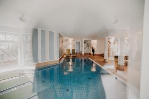 a large swimming pool with a blue tile floor at Villa Usedom in Heringsdorf
