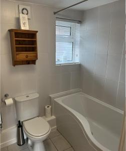 a bathroom with a toilet and a bath tub at The Garden Apartment in Ironbridge