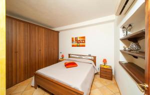 カステルサルドにあるVilla Antonellaのベッドルーム1室(ベッド1台付)、木製キャビネットが備わります。