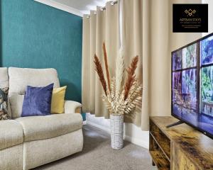 a living room with a couch and a television at The Gem of Basildon By Artisan Stays I Free Parking I Weekly Or Monthly Stay Offer in Basildon