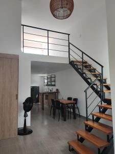 eine Treppe in einem Zimmer mit einem Tisch und Stühlen in der Unterkunft Lagom Apartamentos San Rafael in San Rafael