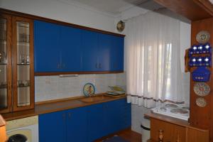 eine Küche mit blauen Schränken und einem Waschbecken in der Unterkunft ZeusPlace Georgia Blue in Leptokaryá