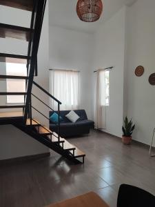 ein Wohnzimmer mit einer Treppe und einer Couch in der Unterkunft Lagom Apartamentos San Rafael in San Rafael