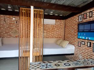 1 Schlafzimmer mit 2 Betten in einer Ziegelwand in der Unterkunft Suite en Getsemaní - POD C in Cartagena de Indias