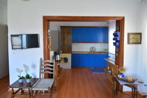 eine Küche mit blauen Schränken sowie einem Tisch und Stühlen in der Unterkunft ZeusPlace Georgia Blue in Leptokaryá
