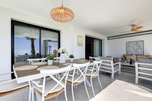 uma sala de jantar com mesa e cadeiras em Ground floor 4 Bedroom Apartment @ Estepona Hills! em Estepona