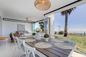 uma sala de jantar com uma mesa e cadeiras e uma palmeira em Ground floor 4 Bedroom Apartment @ Estepona Hills! em Estepona
