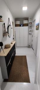 a kitchen with white cabinets and a brown rug at EL RINCON DORADO in Melilla