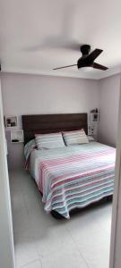 1 dormitorio con 1 cama y ventilador de techo en EL RINCON DORADO en Melilla