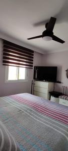 a bedroom with a bed and a ceiling fan at EL RINCON DORADO in Melilla