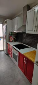 a kitchen with red cabinets and a stove top oven at EL RINCON DORADO in Melilla