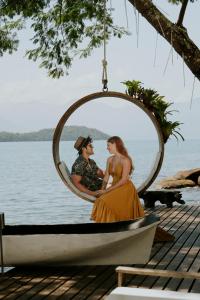 a man and woman sitting in a round mirror on a boat at Pousada Papiro Boutique in Abraão