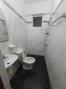 a white bathroom with a toilet and a sink at Horton Studios in Colombo