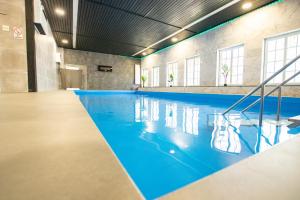 a swimming pool with blue water in a building at Madisson Green El Capitan nähe Movie Park in Schermbeck