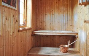 a wooden sauna with a bucket and a window at Awesome Home In Årjäng With Sauna in Årjäng