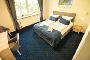 een hotelkamer met een bed met blauwe kussens bij Madisson Green El Capitan nähe Movie Park in Schermbeck