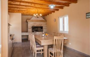 a dining room with a table and chairs and a fireplace at 3 Bedroom Amazing Home In Donji Prolozac in Donji Proložac