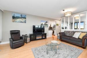a living room with a couch and a tv at Harbour Walk Executive Condo in Victoria