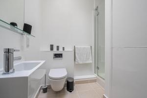 een witte badkamer met een toilet en een douche bij Spacious and Comfy 4 Bedroom House near Oxford Street and marble Arch in Londen