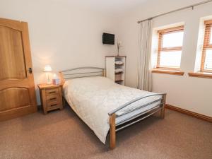 een slaapkamer met een bed en een televisie. bij Laird House in Lockerbie