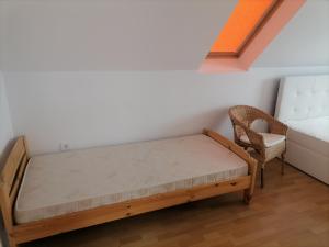 - une petite chambre avec un lit et une chaise dans l'établissement Mesgye Villa, à Balatonalmádi
