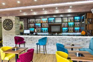 a restaurant with tables and chairs and a bar at Apartmani 29 in Inđija