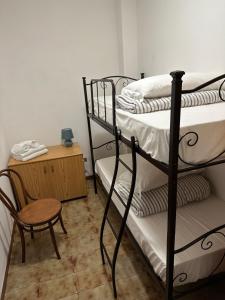a room with two bunk beds and a chair and a table at Coral Apartment in Nettuno
