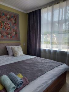 a bedroom with a large bed with a window at Guest House Ruh Achari in Sheki