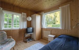 ジルレジェにあるStunning Home In Gilleleje With 2 Bedrooms And Wifiのベッドルーム1室(ベッド1台、テレビ、窓2つ付)