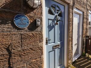 a blue door on the side of a brick building at Navigators Rest in Whitby