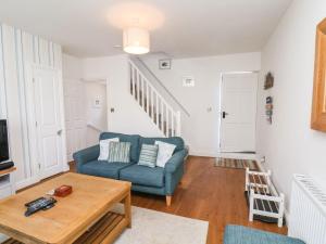 a living room with a blue couch and a table at Navigators Rest in Whitby